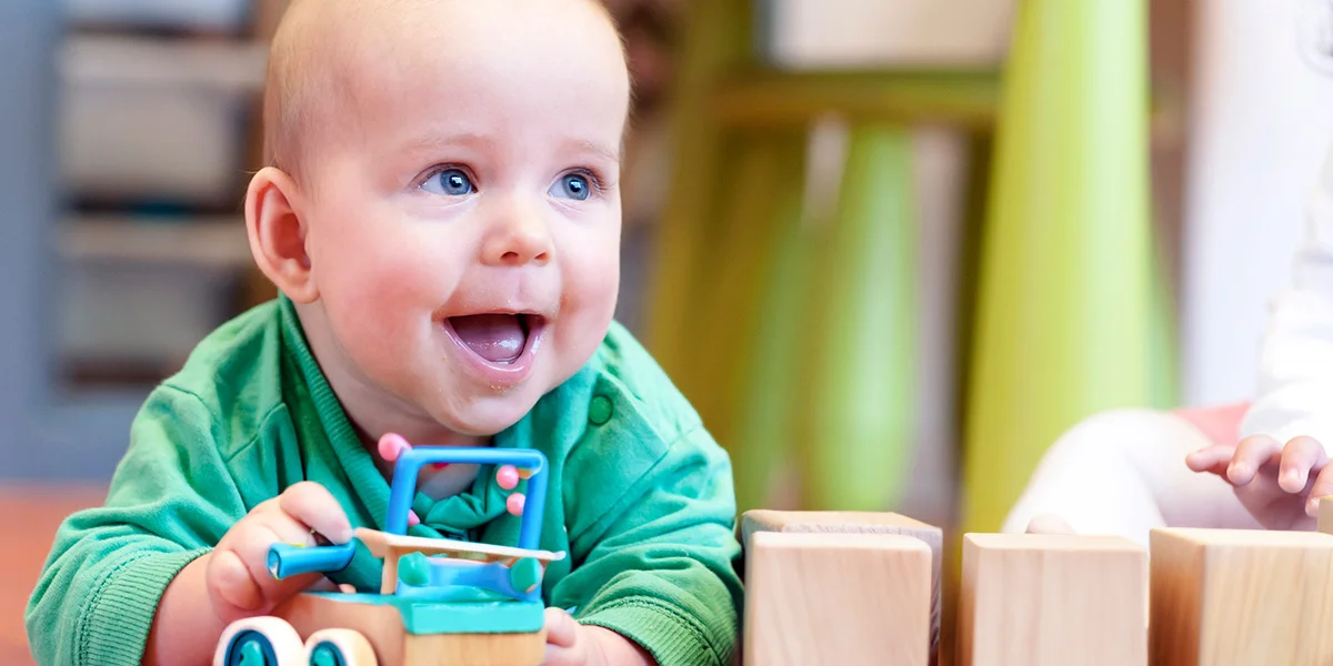 Baby speelt met houten speelgoed in kinderopvang 2Samen Den Haag Monster Naaldwijk