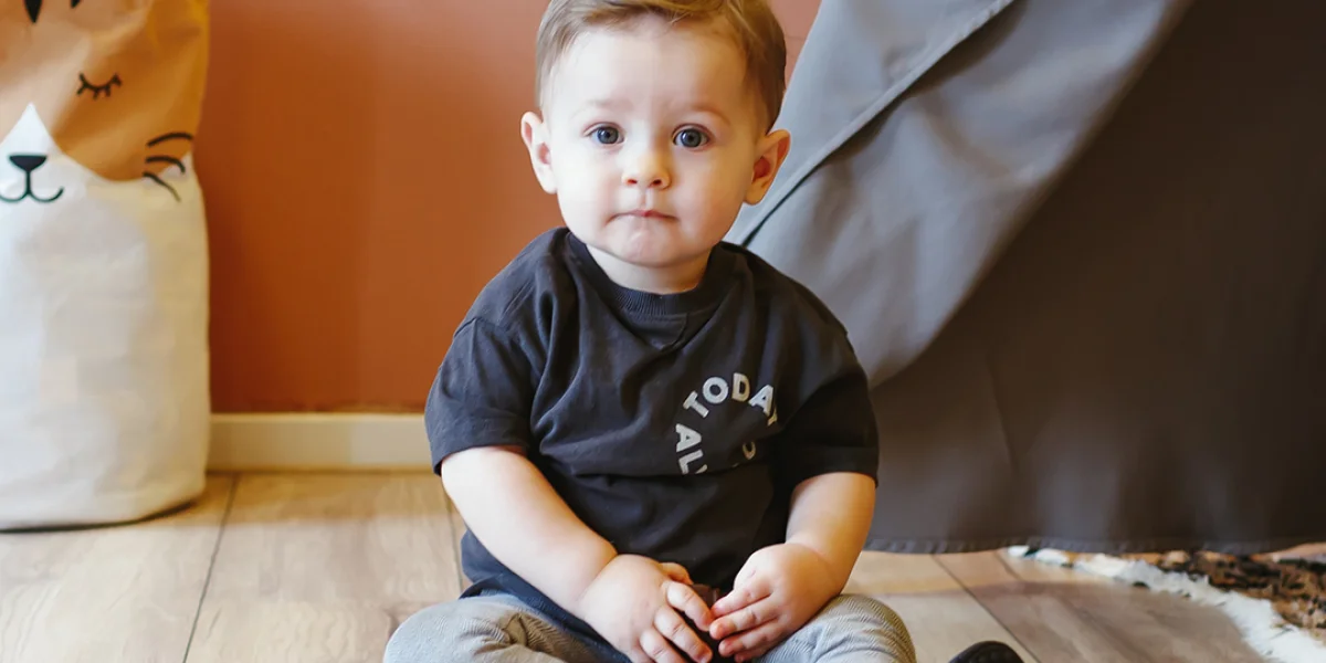 Baby zit op grond bij kinderdagverblijf Kids Lodge